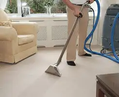 Carpet cleaning professional removing dirt and stains with a hot-water extraction tool in a home, Sacramento, CA.