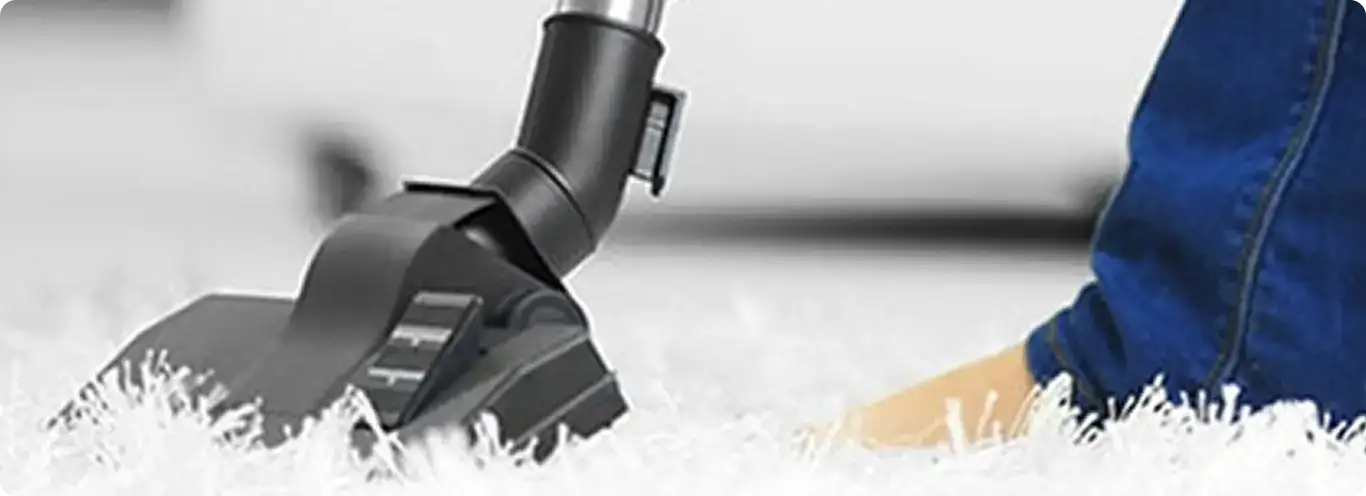 Close-up of a professional vacuuming a white carpet in North Highlands.